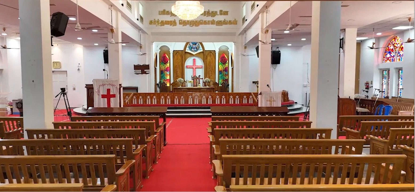 The altar, stained-glass windows and central aisle of CSI Wesley Tamil Church